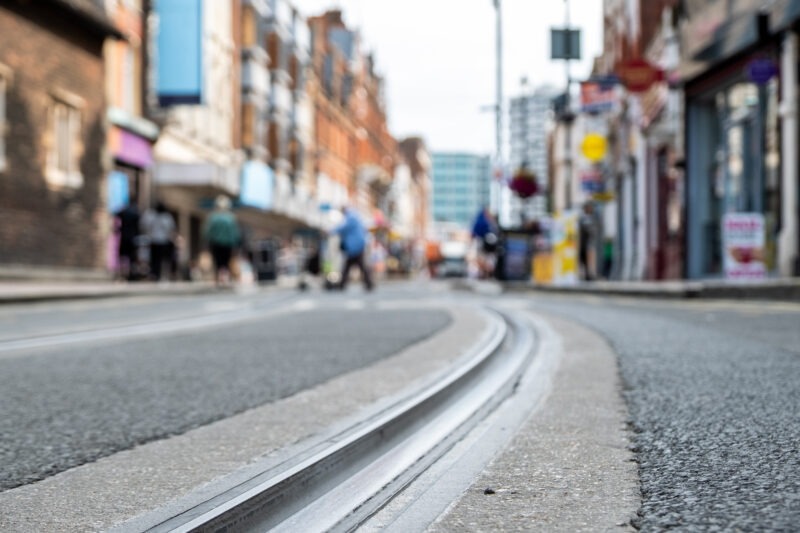 British high street shops close focused in tram tracks on the road- Croydon, South London British high street shops close focused in tram tracks on the road- Croydon, South London